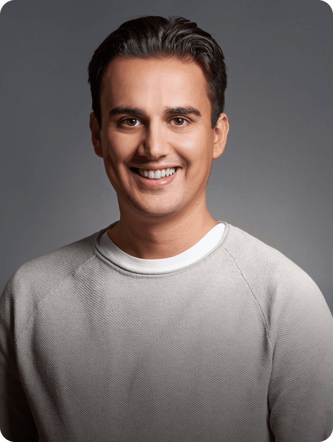 Linxact founder and CEO Daniel Lux smiling in front of a grey background